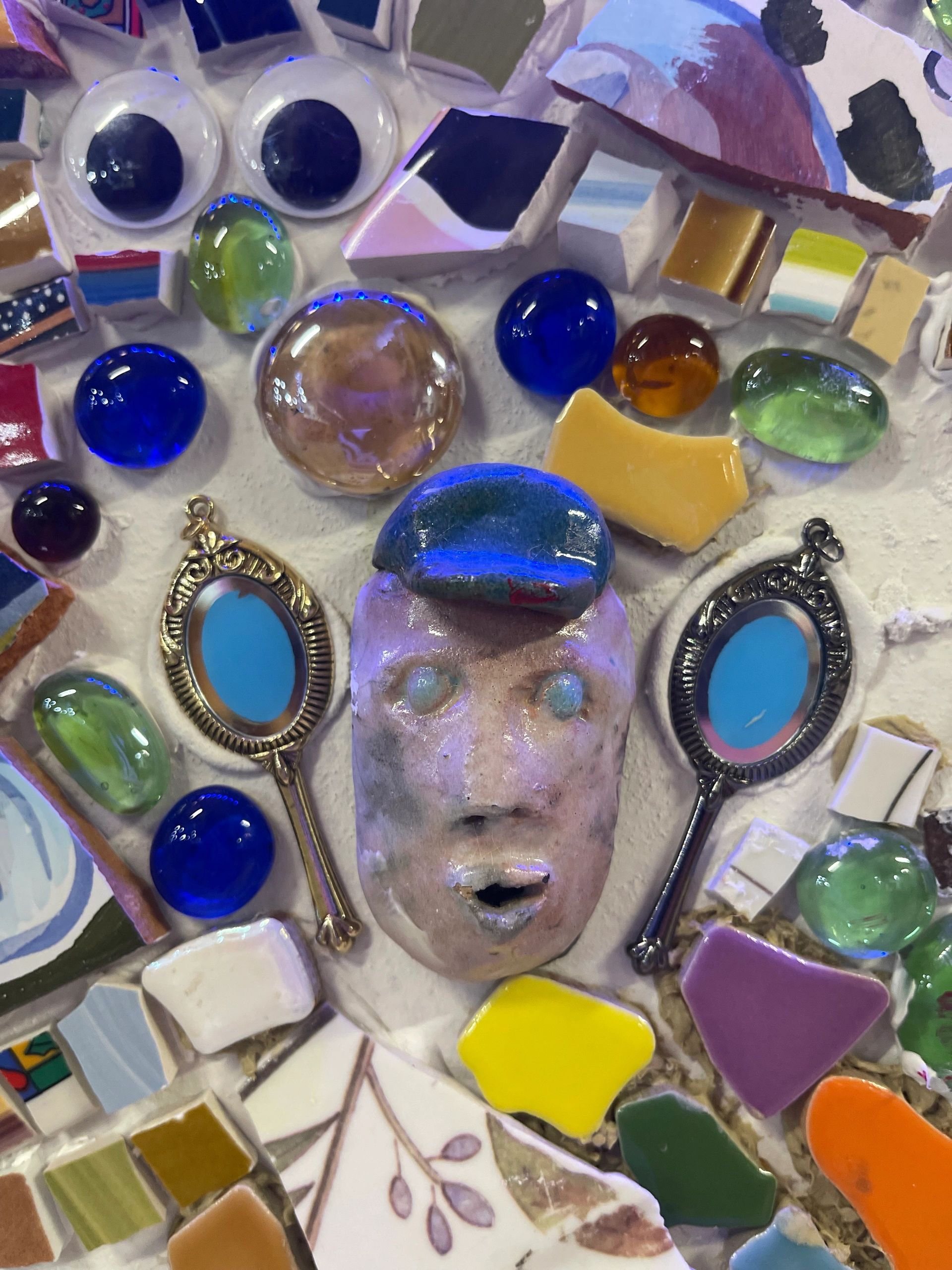 Handmade mosaic face with glass, mirrors, and ceramic pieces by a Canton artist