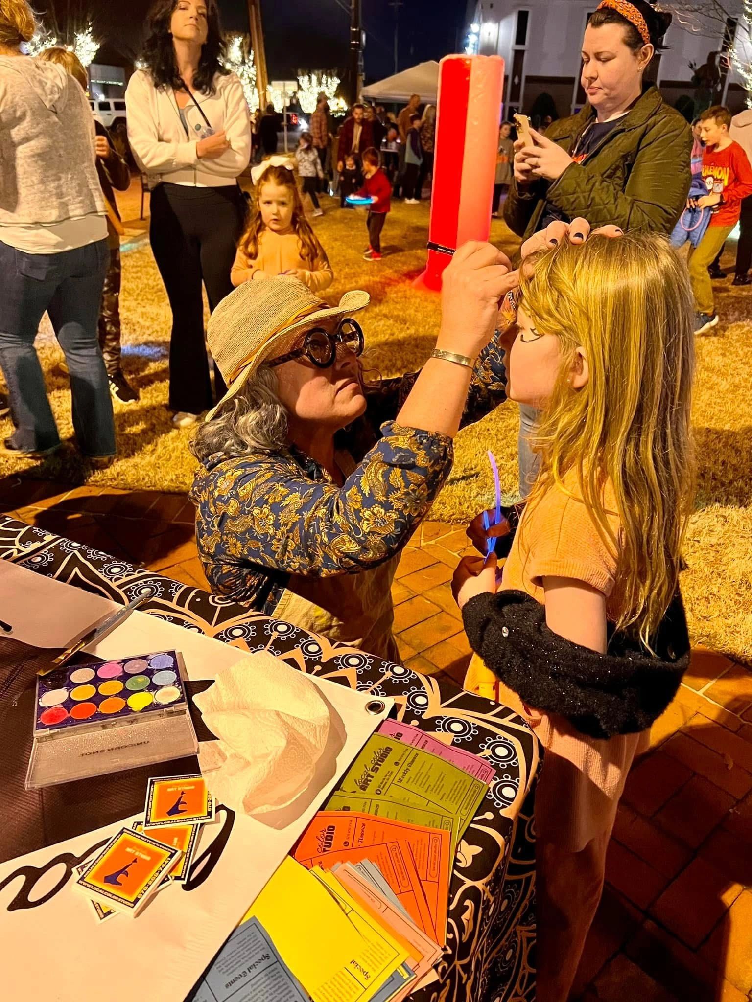 Face painting at an evening arts festival