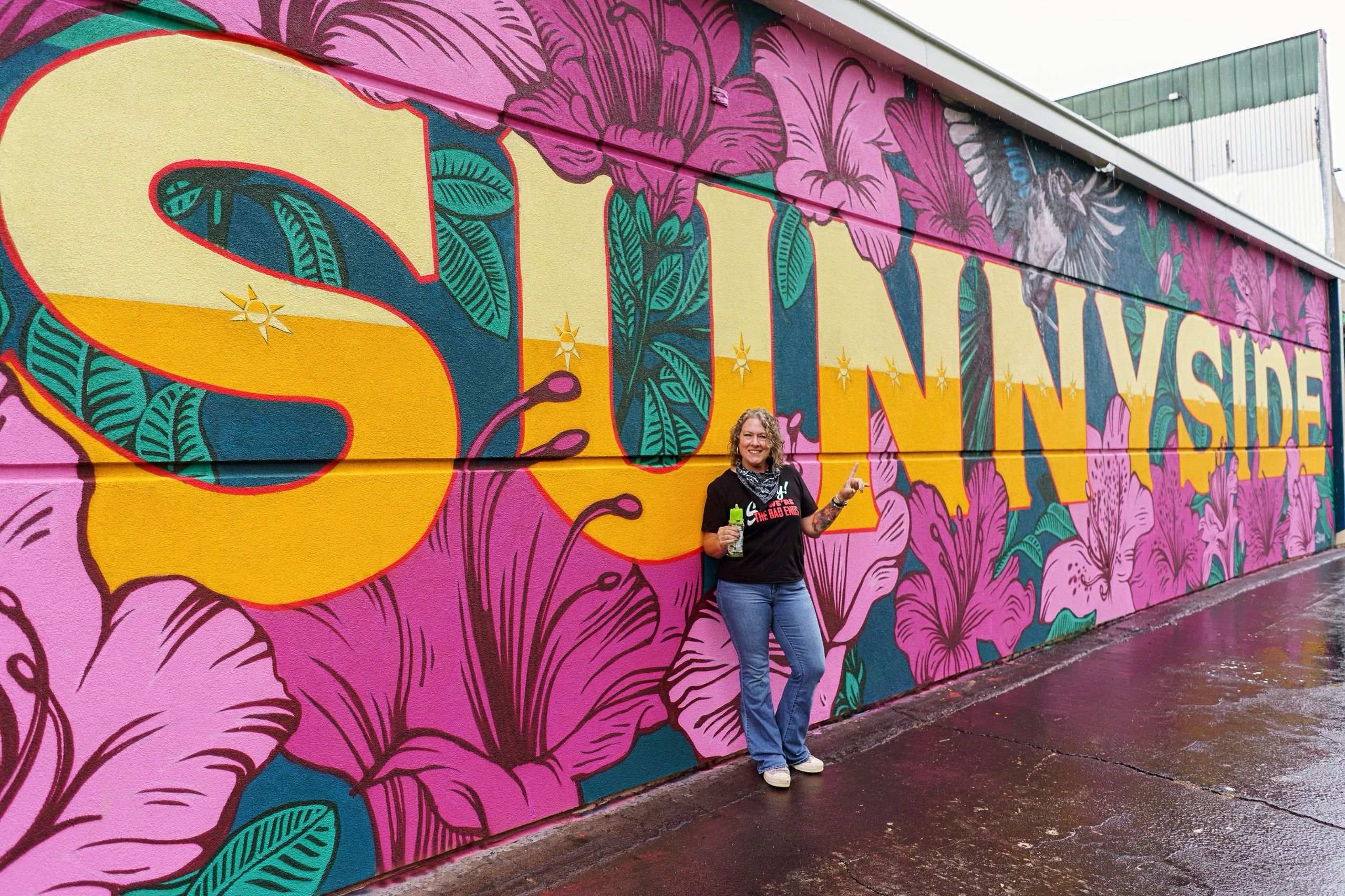 Visitor in front of the bright Sunnyside floral mural