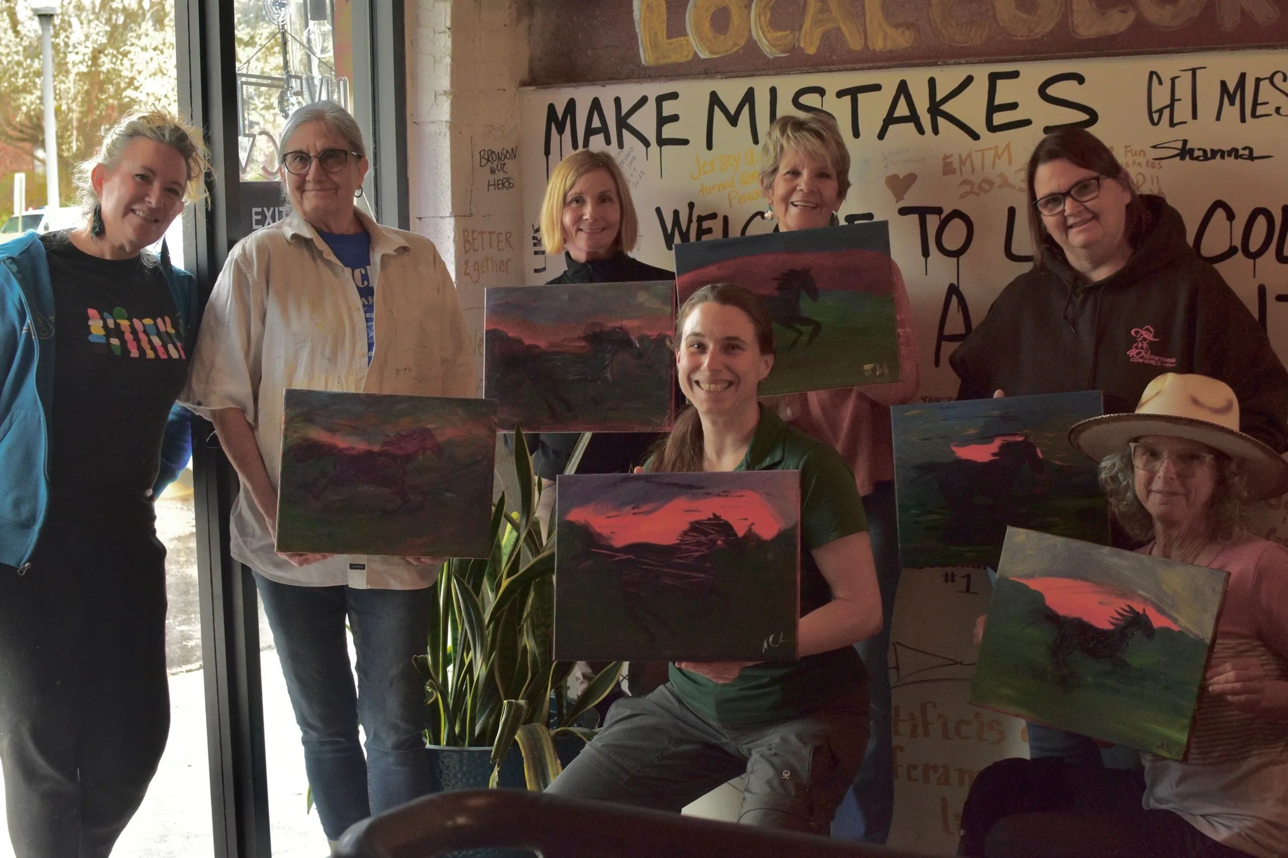 Guild members holding paintings they created together